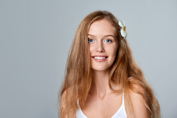Beautiful young woman with flower in hair - Foto, Imagem