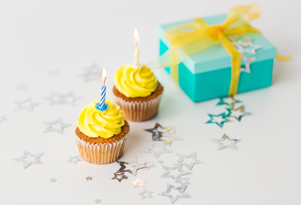 birthday cupcakes with burning candles and present - Fotó, kép