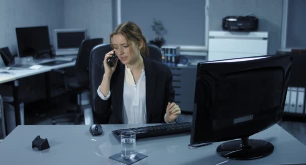 4К: Молодая сотрудница сидит напряженно в своем офисе. Телефонный звонок нарушает работу ее компьютера
.  - Кадры, видео