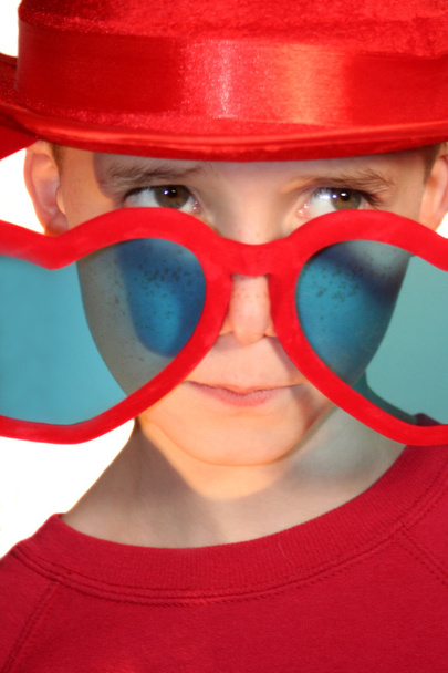 Garçon regardant avec hérésie sur des lunettes en forme de coeur
 - Photo, image