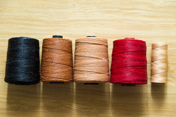 Muitos fios de costura coloridos de couro crafting na mesa de madeira
. - Foto, Imagem