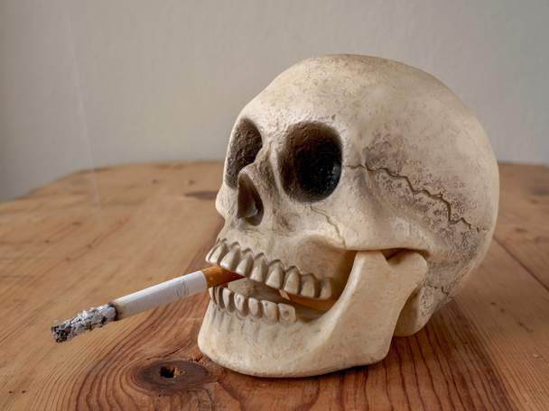 Close up of human skull  smoking cigarette  - Fotó, kép