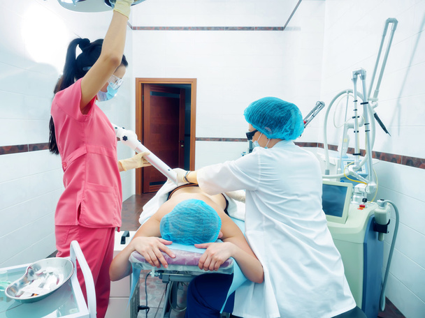 Laserbehandlung. Kaukasischer Arzt macht Eingriff Hautnävus Entfernung an Frau Patientin - Foto, Bild