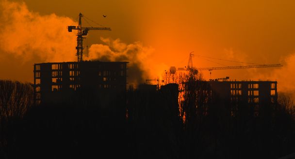 Huis in aanbouw in mistige verdamping bij zonsondergang, achtergrond - Foto, afbeelding