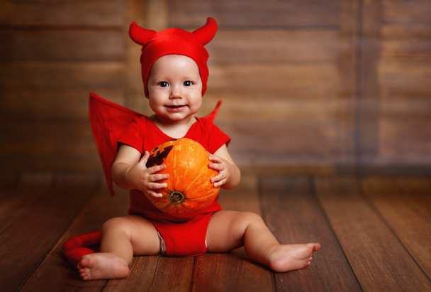 смішна дитина в костюмі диявола Хелловін з гарбузом
  - Фото, зображення