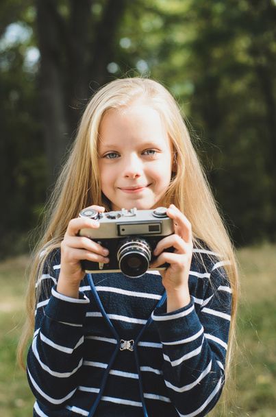 Милая маленькая девочка с винтажным дальномерным фотоаппаратом
. - Фото, изображение