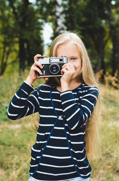 Aranyos kis lány vintage távolságmérő kamerával. - Fotó, kép