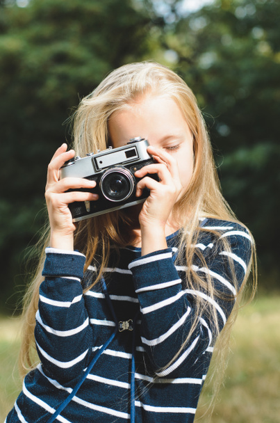 Симпатична маленька дівчинка з старовинною камерою далекомір
. - Фото, зображення