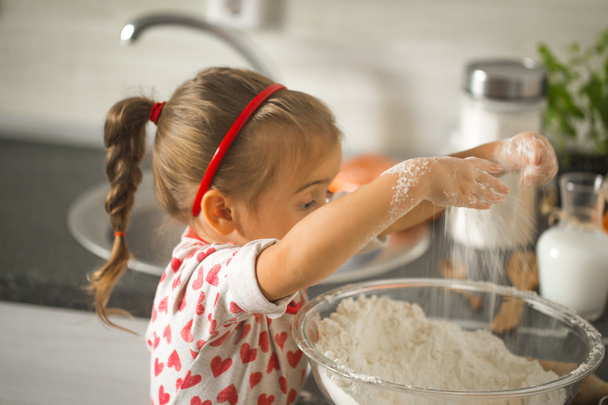 красивая маленькая девочка Бейкер на кухне
 - Фото, изображение