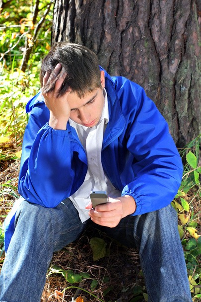 Sad young man with phone - Foto, afbeelding