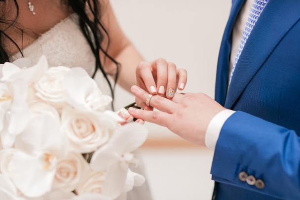 El primer plano de la novia que pone el anillo de boda al novio
 - Foto, imagen