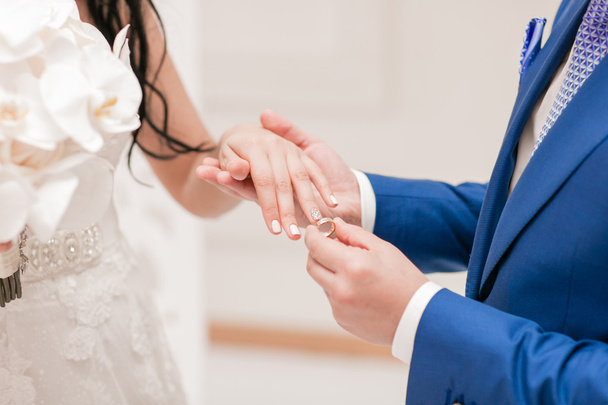 ο γαμπρός και η νύφη πιασμένοι από τα χέρια - Φωτογραφία, εικόνα