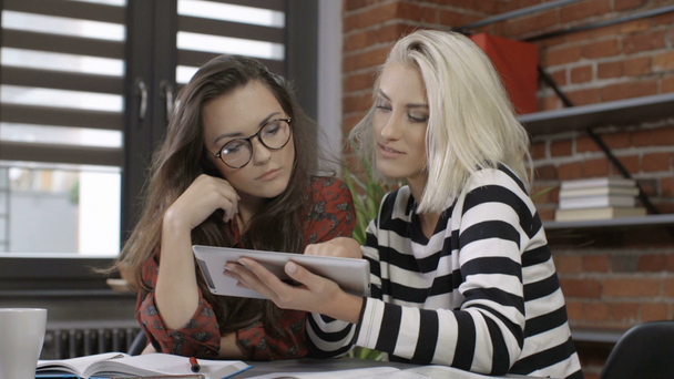 Δυο όμορφα νεαρά κορίτσια σπουδάζουν στο μοντέρνο διαμέρισμα. - Πλάνα, βίντεο