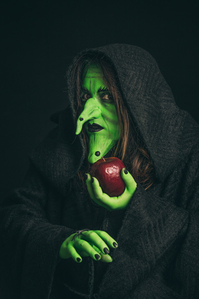böse Hexe mit einem faulen Apfel und einer Spinne an ihren Händen - Foto, Bild