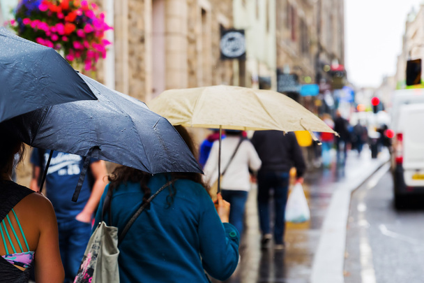 people with rain umbrellas in the city - Valokuva, kuva