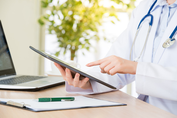 doctor using digital tablet to research patient's medical case - Fotografie, Obrázek
