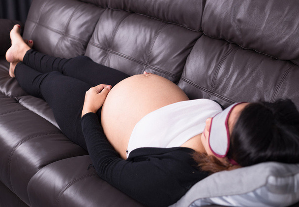Pregnant woman sleeping on sofa - Photo, Image