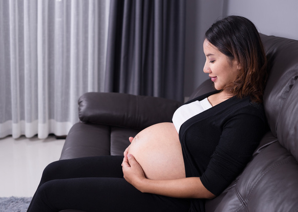 妊娠中の女性が自宅のソファの上で安静時 - 写真・画像