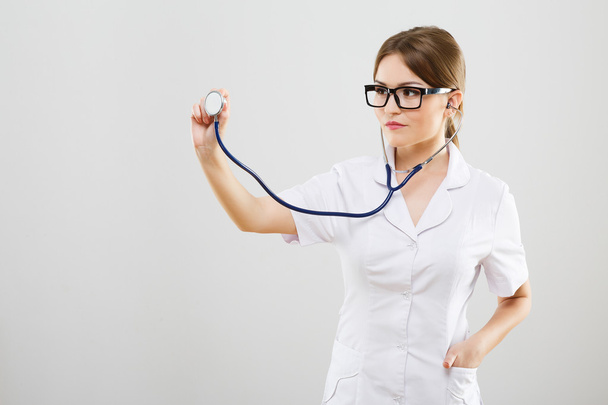 Kaunis sairaanhoitaja valkoisessa lääketieteellisessä kaapussa
 - Valokuva, kuva
