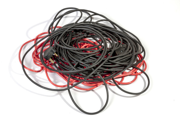  Pilha de cabos de extensão elétricos vermelhos e pretos laminados
 - Foto, Imagem