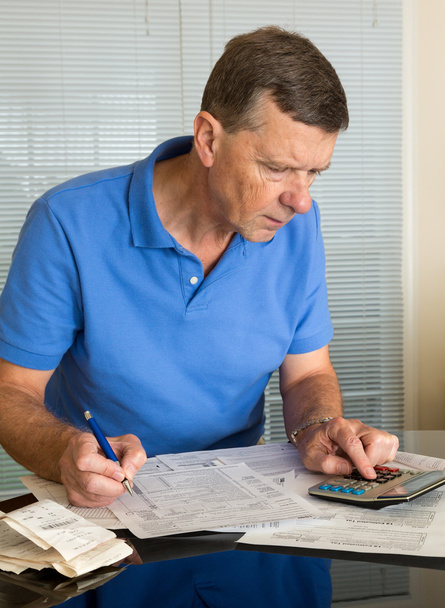Vanhempi mies, joka laatii Yhdysvaltojen verolomakkeen 1040 vuodelle 2012
 - Valokuva, kuva