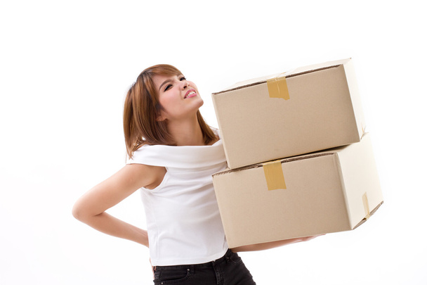 unhappy woman carrying heavy box with back pain - 写真・画像