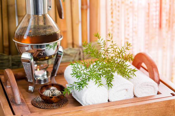 Ainda vida fresca, chá de ervas quente em uma bandeja com toalhas e ervas no spa
. - Foto, Imagem