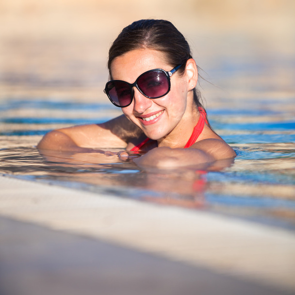 πορτρέτο μιας νεαρής γυναίκας που χαλαρώνοντας στην πισίνα - Φωτογραφία, εικόνα