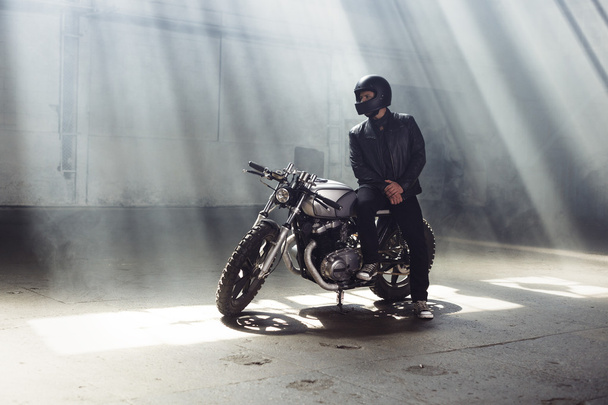 biker wearing jeans and leather jacket sitting on motorcycle - Zdjęcie, obraz