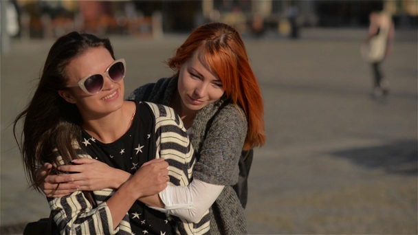 Kaksi tyttöä ystäviä nuoria naispuolisia ystäviä antaa reppuselässä lomalla nauraa ja kävely kaupungissa, aurinkoinen päivä
 - Materiaali, video