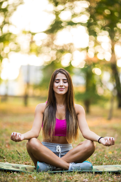 Giovane donna che fa yoga nel parco
 - Foto, immagini