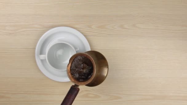 Turk gieten vers gebrouwen koffie naar een klassieke cup - Video