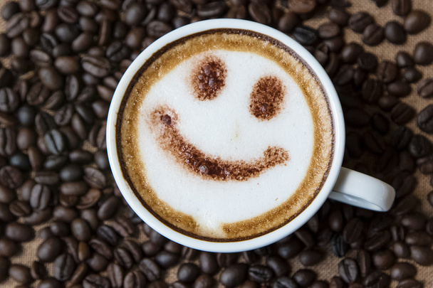 Felülnézet fehér csésze latte art boldog mosollyal arcán  - Fotó, kép