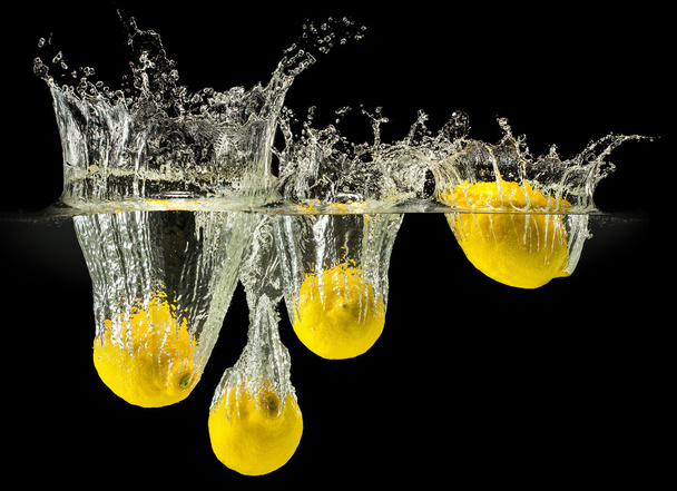 Group of fresh fruits falling in water with splash on black background - Zdjęcie, obraz