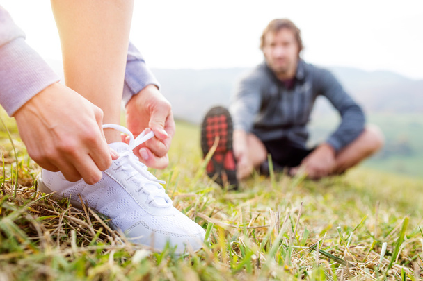 Couple of runners sitting on grass - 写真・画像