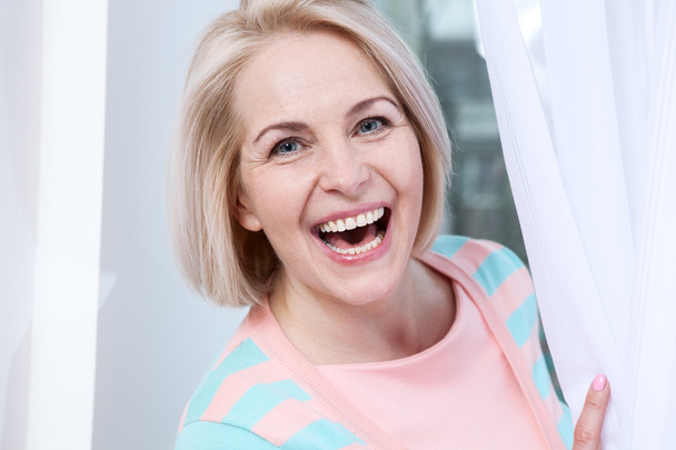 Smiling attractive middle aged woman relaxing at home. The beautiful face close up. - Foto, Bild