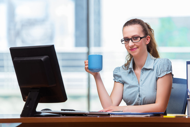 Businesswoman sitting at the office desk - Фото, изображение