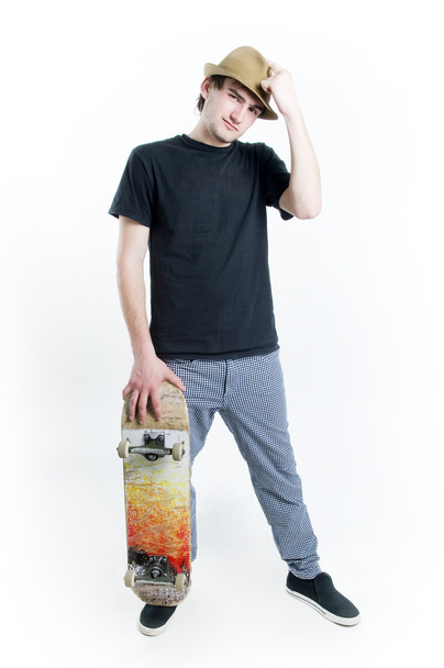 Serious looking teenager with skate - Φωτογραφία, εικόνα