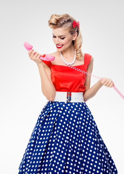 smiling woman with phone, dressed in pin-up style dress - Fotoğraf, Görsel