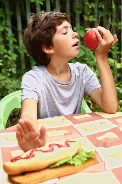 hezký chlapec jíst jablko odmítnout hot dog - Fotografie, Obrázek