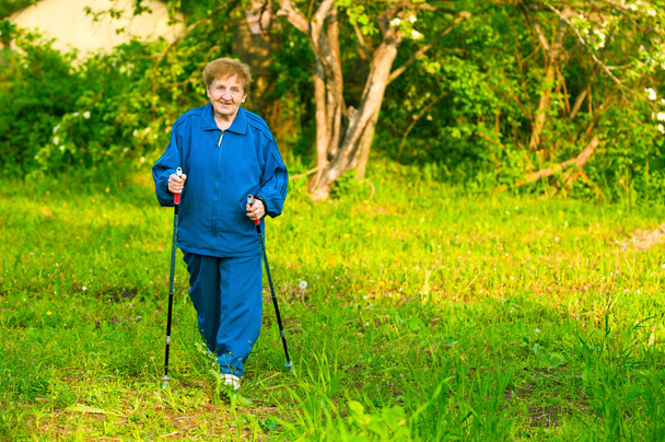 Vieille femme active (85 ans) marche nordique à l'extérieur
. - Photo, image