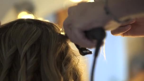 Stylista curling włosy dla młodej kobiety - Materiał filmowy, wideo