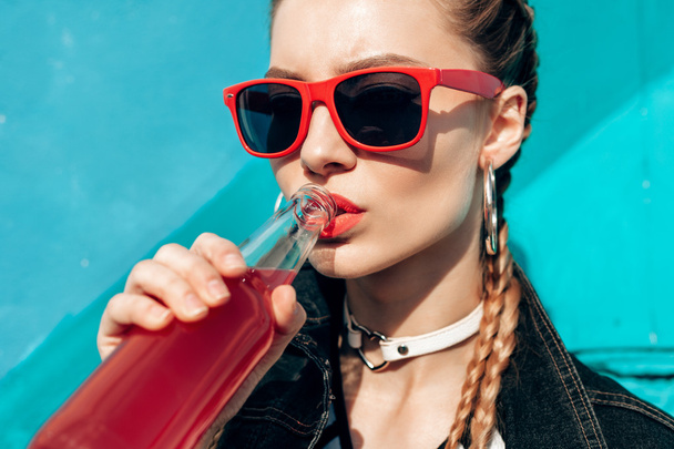 Mujer joven bebiendo coloridos cócteles de botellas
 - Foto, Imagen