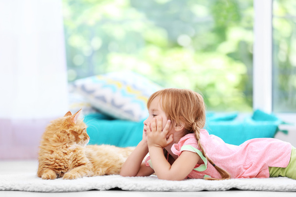 Cute little girl and red cat - Foto, afbeelding