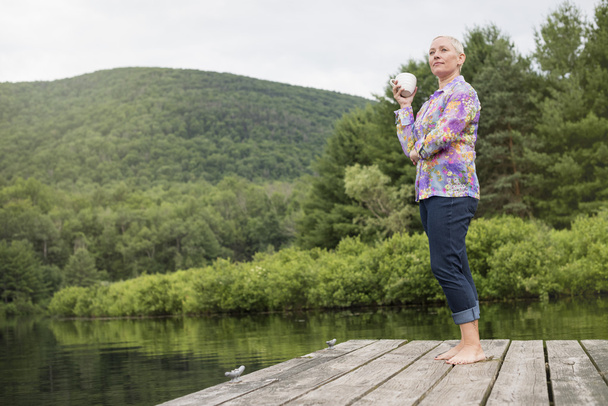 bir göl kenarında duran kadın dock - Fotoğraf, Görsel