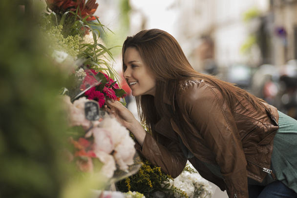 vrouw buigen om te ruiken de geur van bloemen - Foto, afbeelding