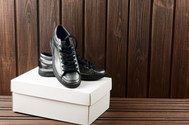 Kožené horní kovové trandy Dámské boty na hnědé dřevěné backg - Fotografie, Obrázek