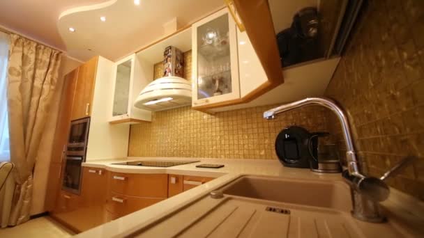 Fregadero en cocina con muebles dorados y electrodomésticos empotrados
 - Imágenes, Vídeo