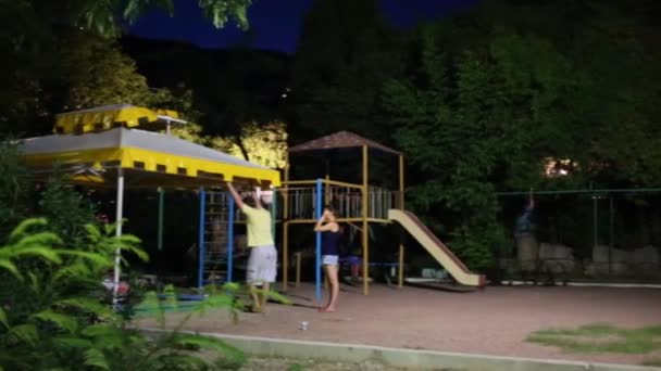 People with children on playground at summer night - Felvétel, videó