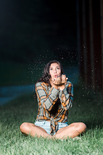Teenage girl caucasian blowing glitter from her hands sitting - Foto, Imagem